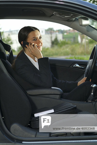 Young businesswoman phoning in her car