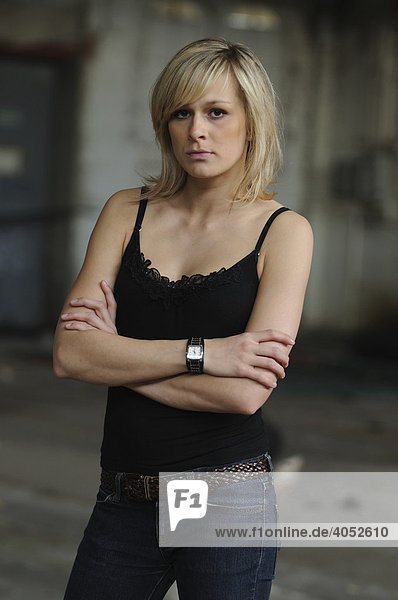 Young blonde woman wearing a black top in a hall  serious  sexy  self-assured