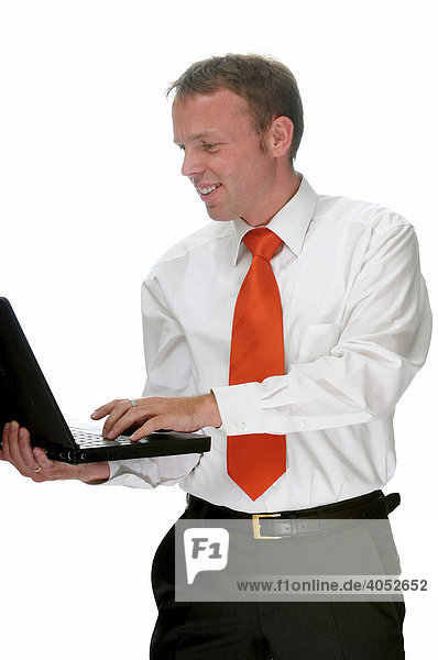 Geschäftsmann mit Hemd und roter Krawatte arbeitet am Laptop