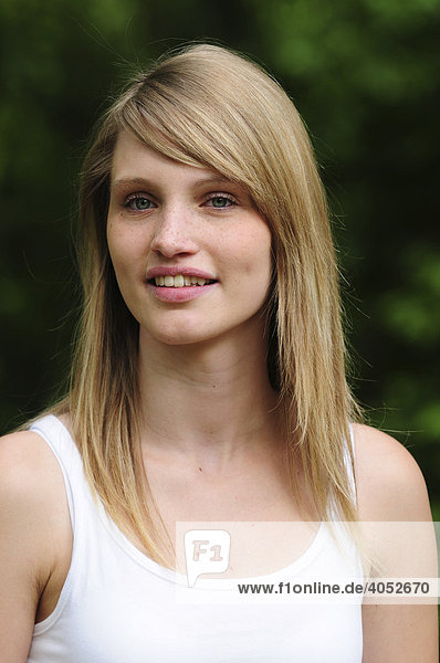 Portrait junge  schöne  blonde Frau im Sommer im Park  lächelt