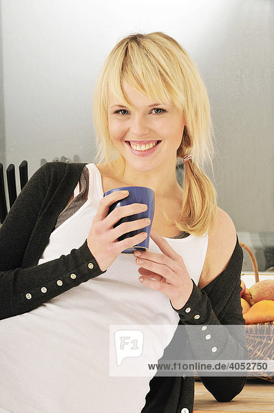 Young blond woman having a cup of coffee