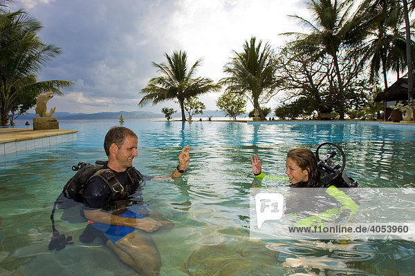 Scuba diving teacher giving a girl a lesson in a swimming pool  Indonesia  Southeast Asia