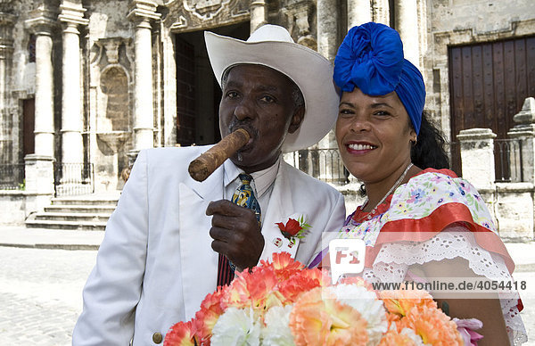 Frau mit Blumen und Mann mit Zigarre lassen sich für Touristen fotografieren  Altstadt von Havanna  Kuba  Cuba  Karibik