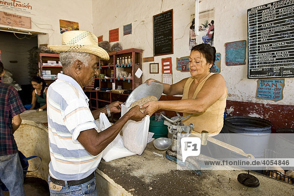 Verkäuferin und Kunde in einem Geschäft für Lebensmittel  die auf Essenskarten an die Kubaner verteilt werden  Trinidad  Kuba  Cuba  Amerika