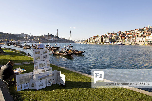 Ein Künstler malt Portweinschiffe  an der Rua Diogo Leite  Fluss Rio Duoro  hinten die Altstadt von Porto  UNESCO Weltkulturerbe  Portugal  Europa