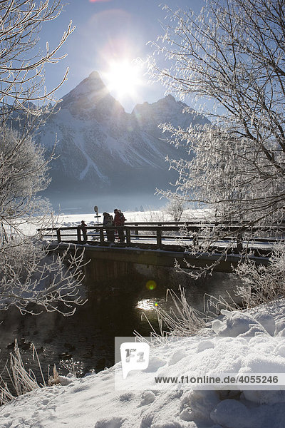 Hikers standing on a snow-covered bridge in front of Sonnenspitze mountain  Tyrol  Austria  Europe