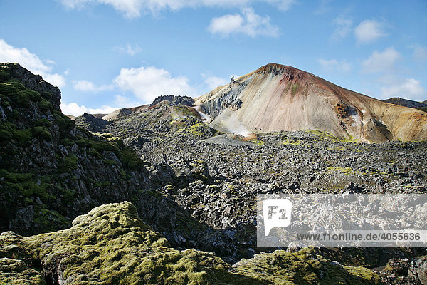 Der bunte  von Mineralien gefärbte Berg Brennisteinsalda  Schwefelwelle  ist von einem Lavafeld umgeben  Landmannalaugar  Island  Europa