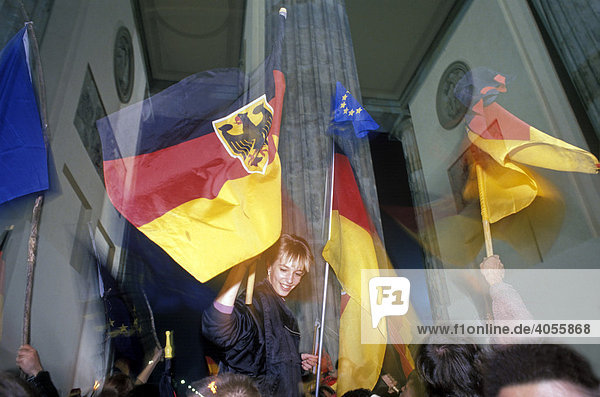 German flags  citizens of Berlin celebrating the reunion of East and West Germany in front of the Brandenburger Tor at night  DDR  October 3rd 1990  Berlin  Germany  Europe