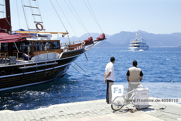 Zwei Männer blicken auf das Meer  Boote im Hafen  Marmaris in der Provinz Mugla  Mittelmeer  Türkei