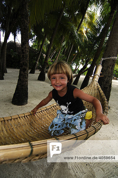 Kind spielt in Hängematte  Baros Resort  Malediven  Indischer Ozean