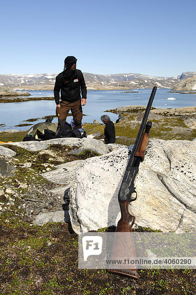 Trekker checking his shotgun for defence against polar bears  Ikasartivaq Fiord  East Greenland
