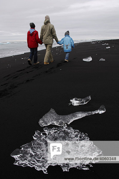 Frau und zwei Kinder  Eisbrocken am Lavastrand  Joekulsarlon  Island  Europa