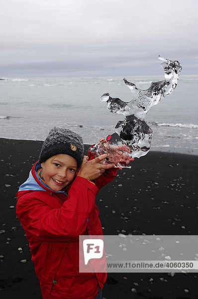 Kind mit Gletschereisbrocken  Joekulsarlon  Island  Europa