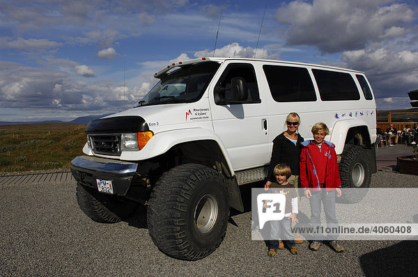 Frau und zwei Kinder vor Allradfahrzeug mit Monsterreifen  Hochland  Island  Europa