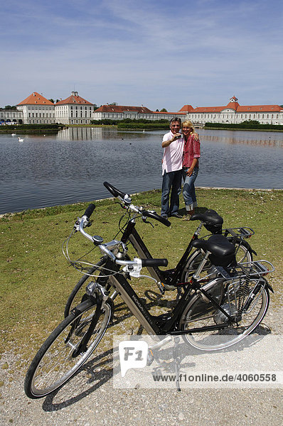 Best Ager  Fahrradfahrer fotografieren sich bei Radtour vor Schloss Nymphenburg  München  Bayern  Deutschland  Europa