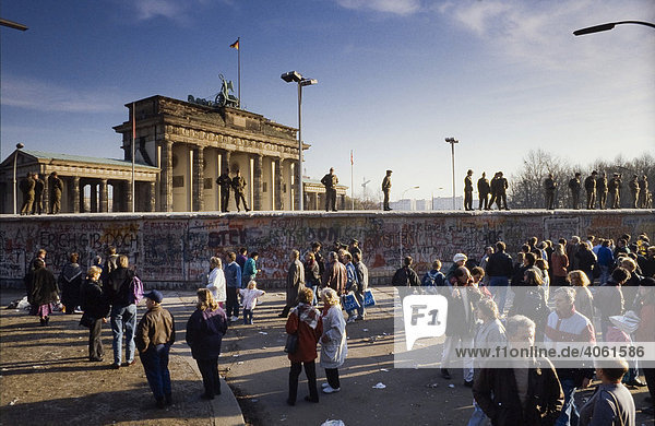 Fall der Berliner Mauer: Grenzsoldaten der nationalen Volksarmee sichern die Mauer am Brandenburger Tor  Berlin  Deutschland  Europa