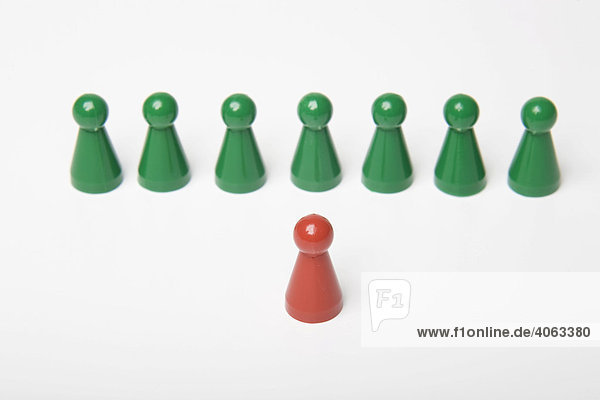 Mehrere grüne und eine rote Spielfigur  Symbolbild Ansprache  Coaching