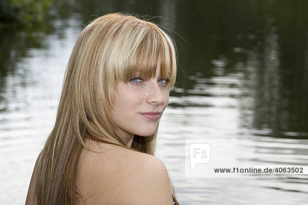 Portrait of a young  blonde woman by the water