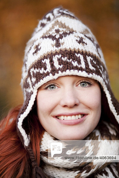 Young red haired woman wearing a woolen hat and scarf  portrait
