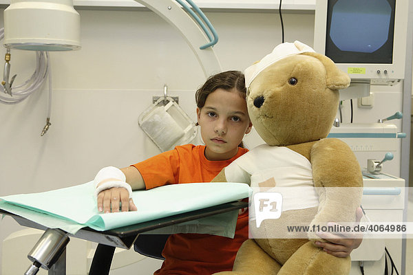 Verletztes Mädchen mit eingebundenem Teddy