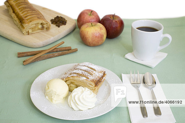 Apfelstrudel mit Vanilleeis und Sahne  Tasse Kaffee  Äpfel  Zimtstangen und Rosinen
