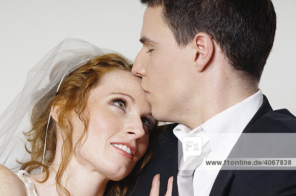 Brautpaar  Bräutigam küsst Braut auf die Stirn