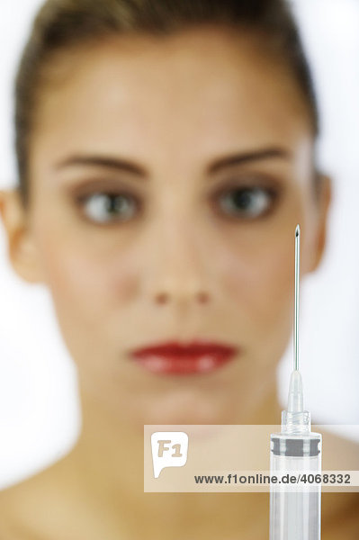Young woman and an injection needle