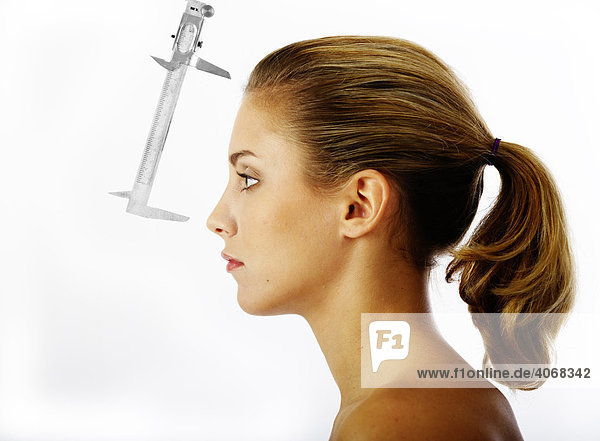 Messung des Abstandes Stirn-Nase einer jungen Frau mit einer Schublehre