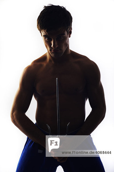Young fighter  bare upper body  holding a trident  dagger or a shortsword  backlit