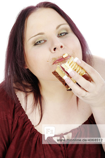 Junge dicke Frau isst eine Torte
