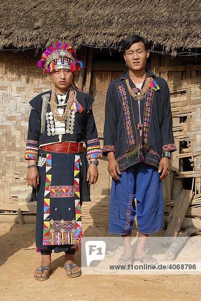 Mann und Frau der Akha Loma Ethnie  beide in bunter traditioneller Tracht gekleidet  Ban Noy  Phongsali Provinz  Laos  Südostasien