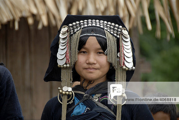 Portrait junge Frau der Akha Phixo Ethnie  traditionelle Kopfbedeckung mit Münzen geschmückt  Ban Phapoun Mai  Phongsali Provinz  Laos  Südostasien