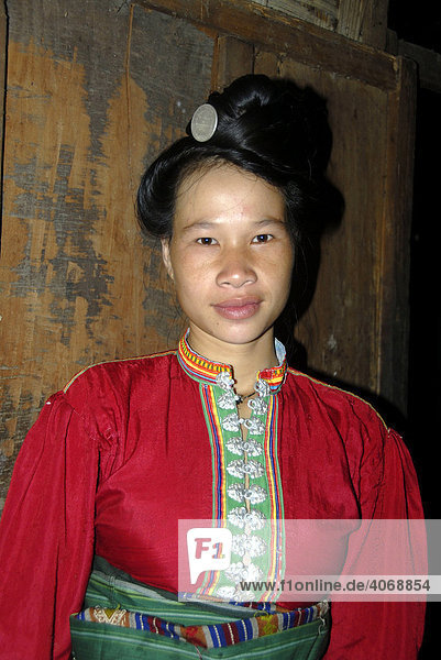 Frau der Tai Dam Ethnie mit hoch gesteckter Frisur und in bunte Tracht gekleidet  Ban Nambone Tai  Phongsali Provinz  Laos  Südostasien