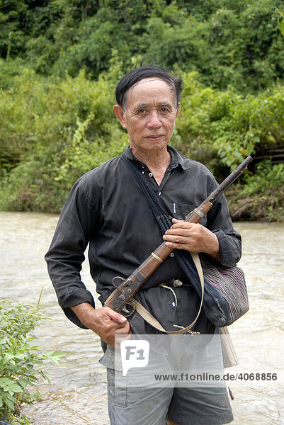 Mann der Tai Yang Ethnie mit einfachem Gewehr auf der Jagd am Fluss  Ban Dongkham  Phongsali Provinz  Laos  Südostasien