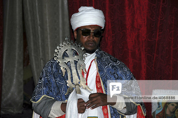 Priester mit weißem Turban und Umhang trägt Lalibela-Kreuz aus Gold  Felsenkirche Beta Medhane Alem  Lalibela  Äthiopien  Afrika
