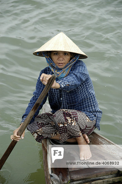 Frau mit Reishut rudert ihr Boot  Hoi An  Vietnam  Südostasien