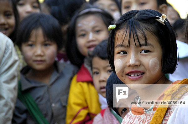 Smiling girl with Tanaka on her face within a group of children  Burma  Myanmar  Southeast Asia