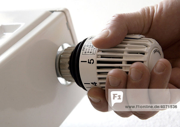 Hand turning a heating thermostat  Germany  Europe