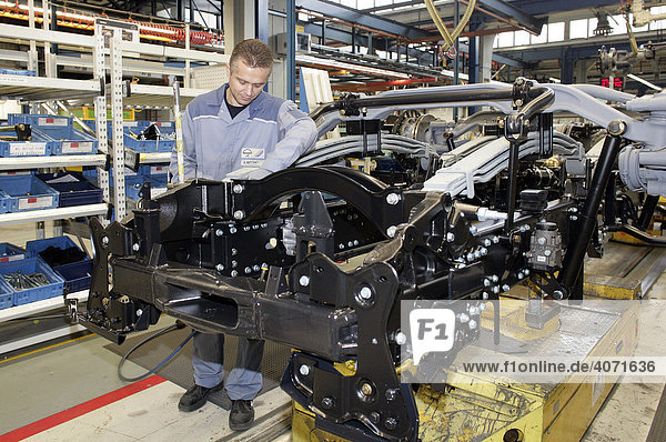 Arbeiter bei Achseinbau im Fahrgestell für Lkw  Fertigung  Produktion MAN Nutzfahrzeuge AG  München  Bayern  Deutschland  Europa
