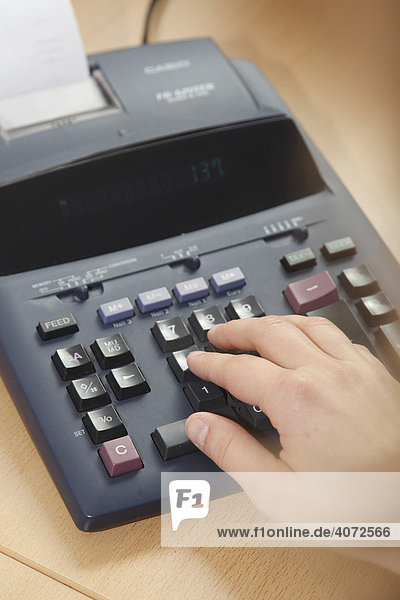 Hand on a desk calculator