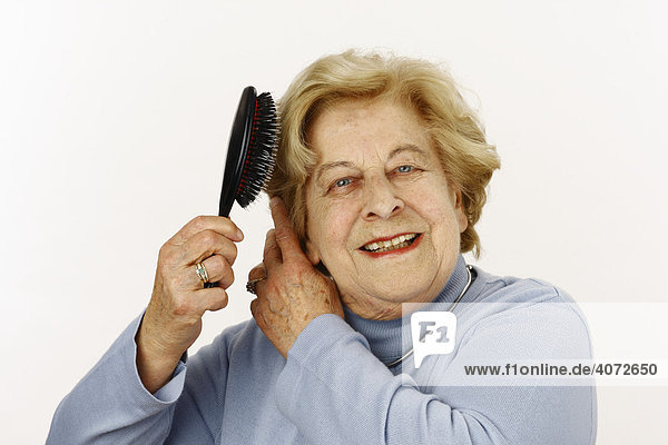 Alte Dame  80-jährige  mit Haarbürste