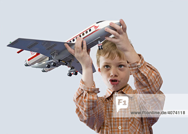 Ein Junge  5 Jahre alt  spielt mit seinem Spielzeug-Flugzeug