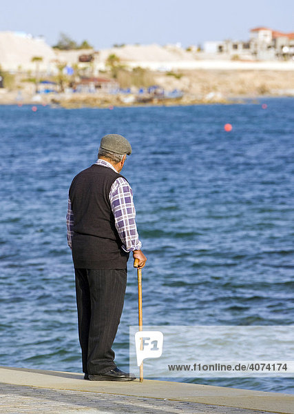 Ein alter Herr mit Krückstock blickt von der Uferpromenade her hinaus aufs Meer  Pafos  Südzypern  Westküste  Zypern  Europa