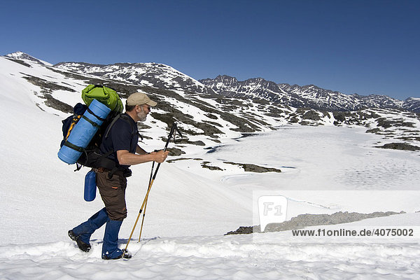 Hiker with backpack crossing a snow field  Chilkoot Trail  Chilkoot Pass  British Columbia  B.C.  Canada  North America