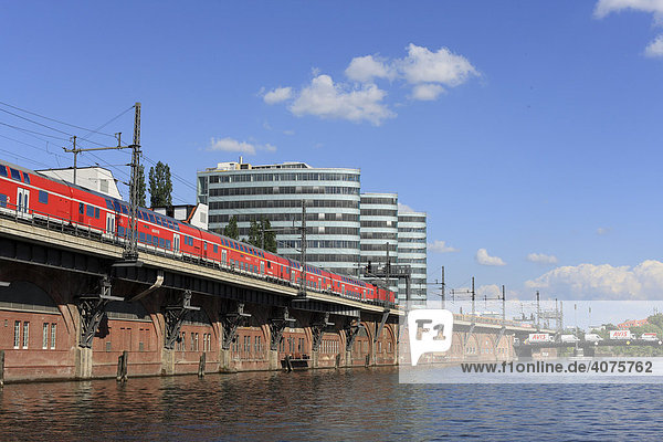 Regional Express  RE  befährt die S-Bahnbögen an der Berliner Spree vor dem Trias Bürogebäude in Friedrichshain-Kreuzberg  Berlin  Deutschland  Europa