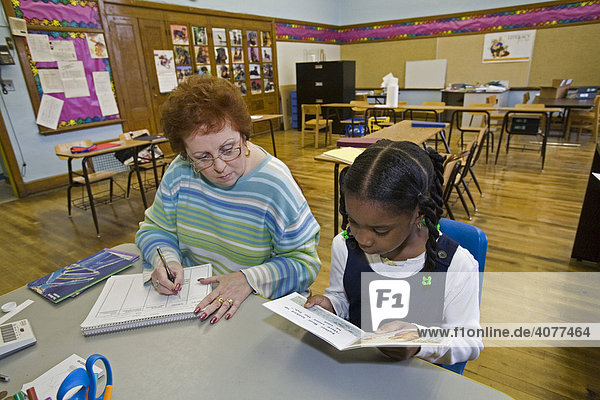 Eine Lehrerin arbeitet mit einer Schülerin im Rahmen eines Leseprogramms in der Grundschule Guyton Elementary School  Detroit  Michigan  USA