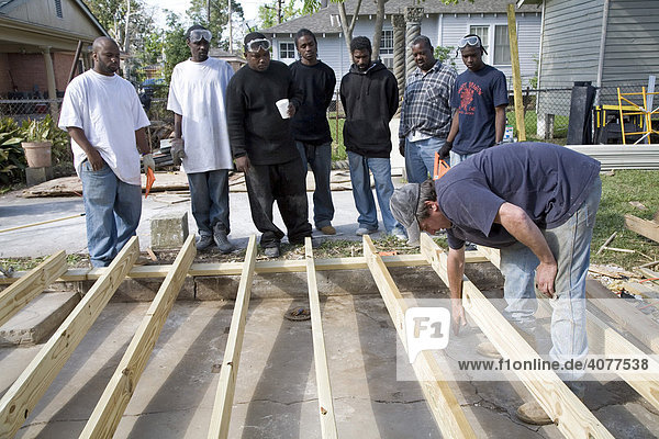 Junge Leute aus der Gemeinde erlernen Baufertigkeiten beim Wiederaufbau eines vom Hurrikan Katrina zerstörten kleinen Hauses im Algiers Viertel  New Orleans  Louisiana  USA