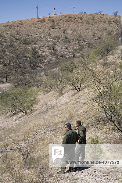 Zwei US-Grenzschutzpolizisten halten Ausschau nach mutmaßlich nicht erfassten Immigranten  die im Bereich unter ihnen gesichtet wurden  unweit der US-mexikanischen Grenze  Nogales  Arizona  USA