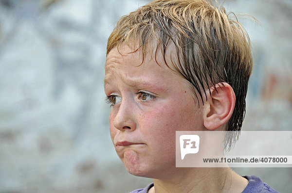 Skeptischer und verschwitzter achtjähriger Junge  Bolzplatz in Köln  Nordrhein-Westfalen  Deutschland  Europa