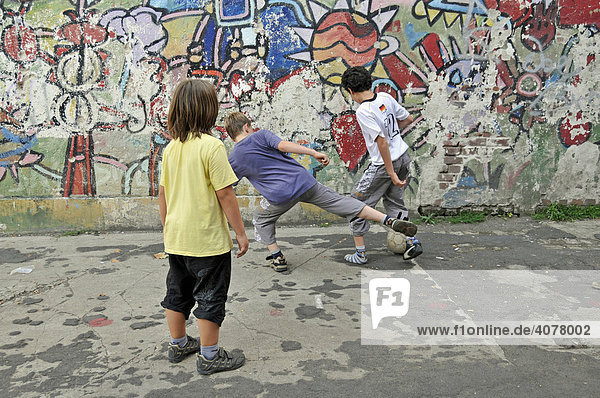 Kinder spielen Fußball  mit Graffiti besprühter Bolzplatz  Köln  Nordrhein-Westfalen  Deutschland  Europa